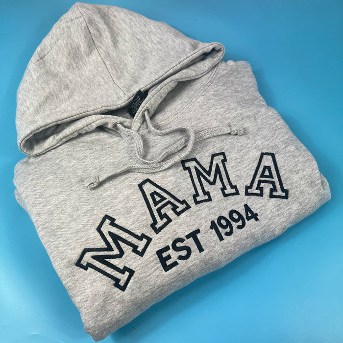 Grey hoodie with mama embroidered in the front in black along with EST 1994