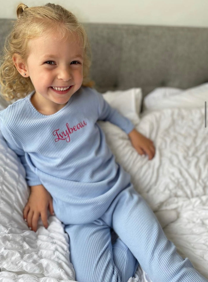 girl wearing Blue Ribbed Childrens Tracksuit with embroided name