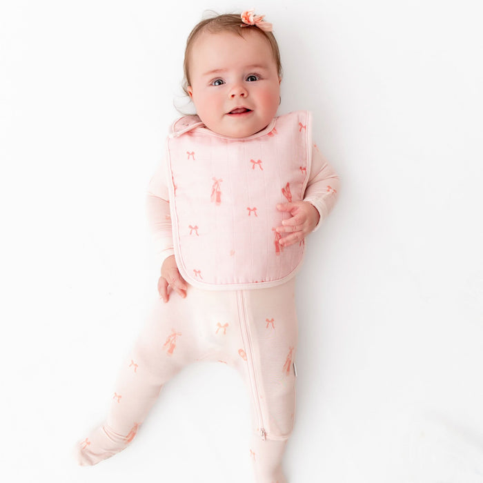 Smiling baby wearing Bamboo Little ballerina bib during mealtime