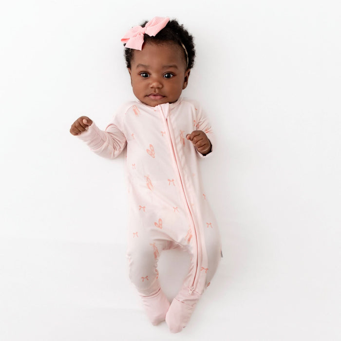 baby in pink ballerina romper with fold over feet