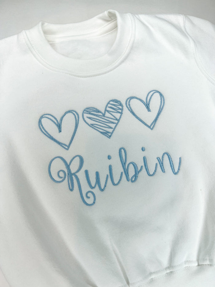 Close of if 3 blue embroidered hearts