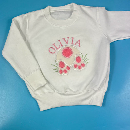 White sweatshirt with a pink bunny graphic and the name 'Olivia' embroidered on the front.