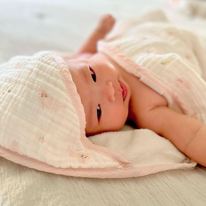 Newborn baby wrapped in a soft pink bunny hooded towel