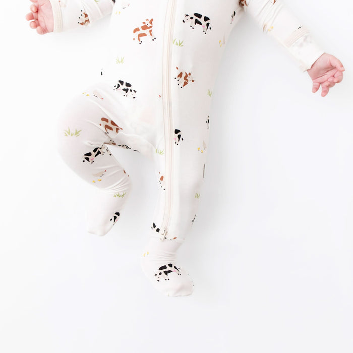 Cow print bamboo baby footie flat lay
