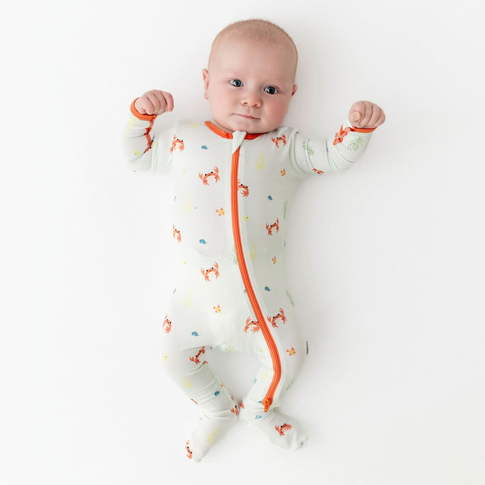 Baby wearing bamboo footie with crab print, front view