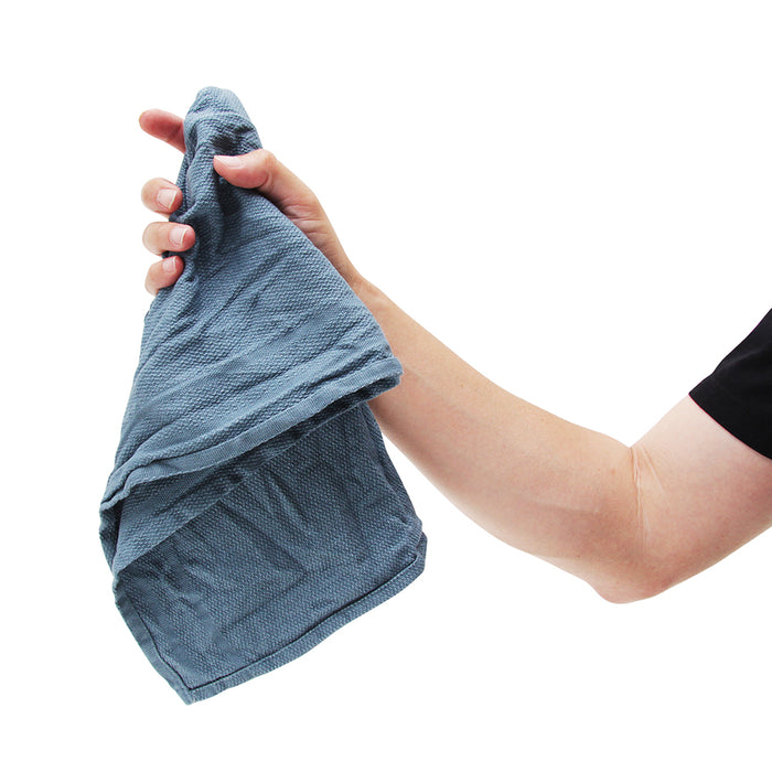 Hand holding a blue towel against a white background