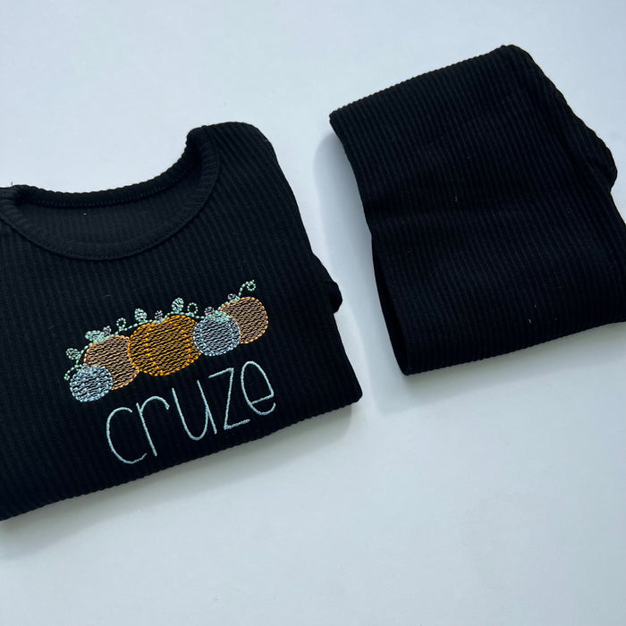 black loungewear with blue and orange pumpkin design with childs name in blue