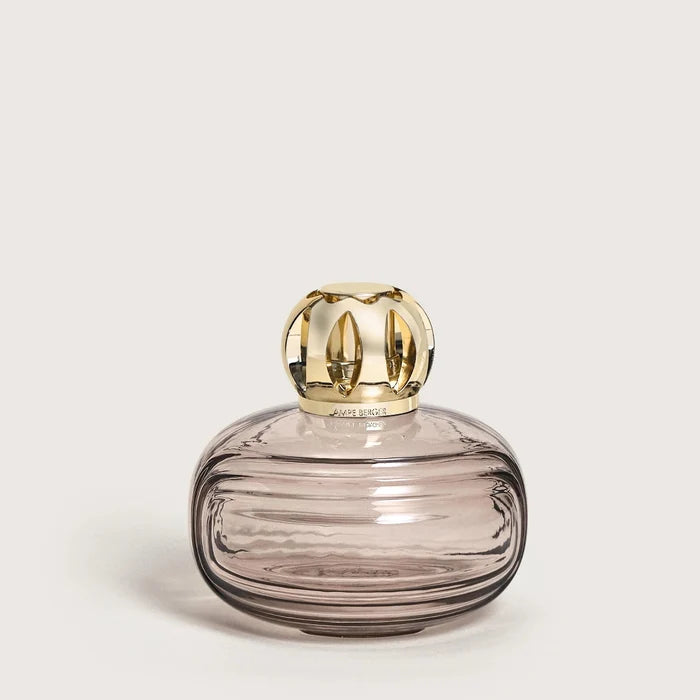 Glass container with gold lid on a light beige background
