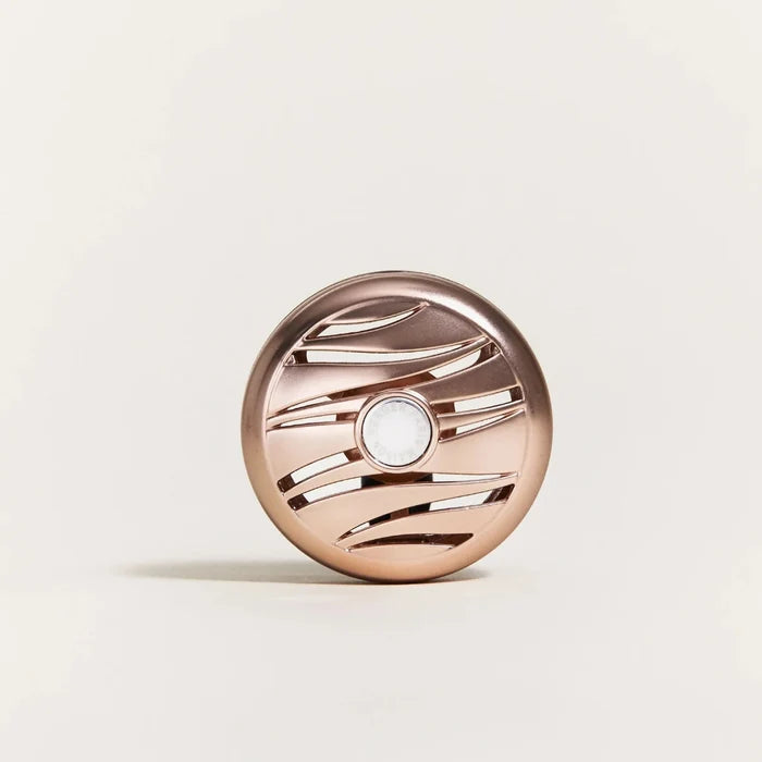 Rose gold car diffuser on a light beige background