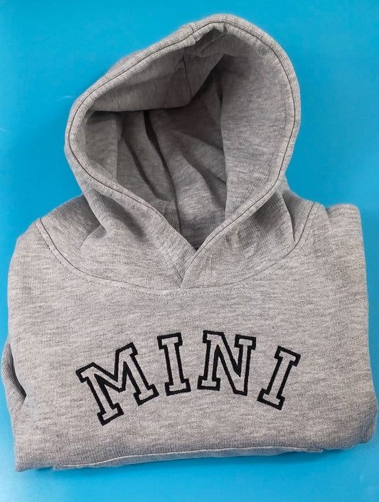 A gray mini hoodie with the word 'MINI' printed in large letters on the front.