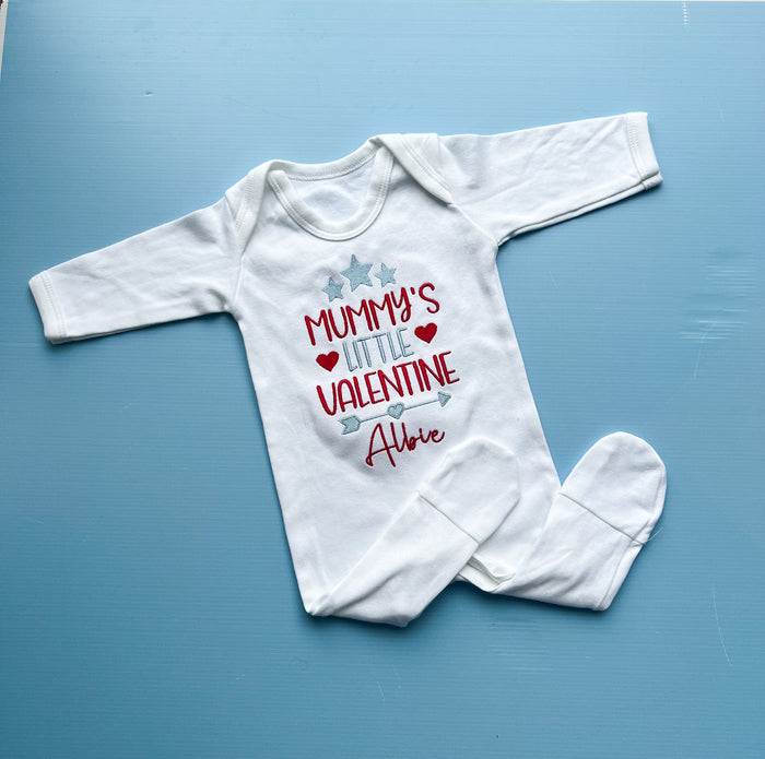 White baby onesie with personalized text on a blue background