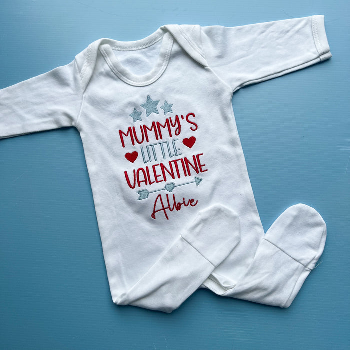 White baby onesie with 'Mummy's Little Valentine' text on a blue background