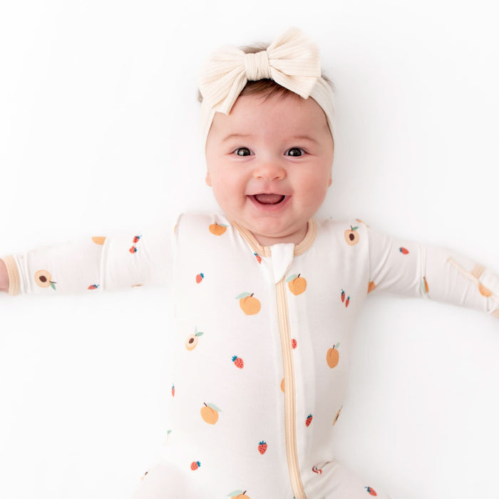Baby wearing peach bamboo zippered footie pajama