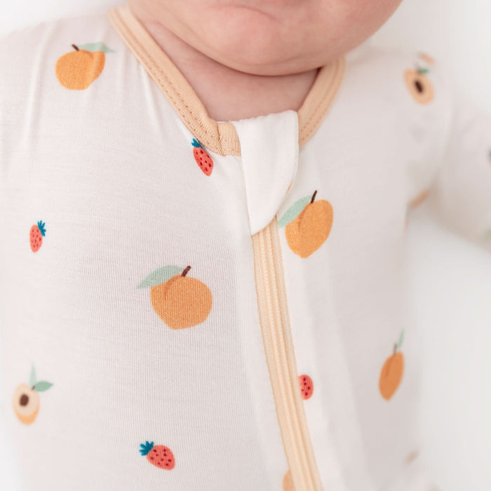 close-up of zipper on peach bamboo baby footie pajama