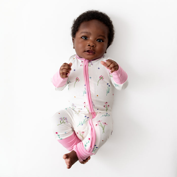 Baby in wildflowers romper, seated lifestyle shot